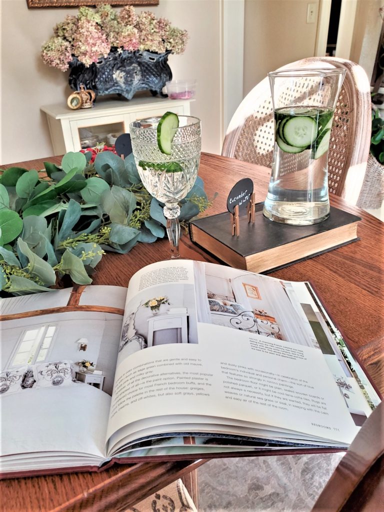 Everything You Need for an Amazing Indoor Garden Party cucumber water in a carafe.   A book open and a water glass filled with cucumber water