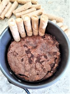 Adding the broken cookies to the side of the cake.