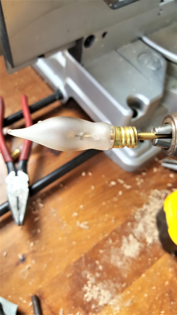 showing the drill bit in the light bulb to, remove filiment