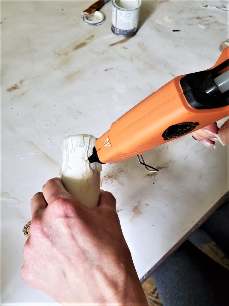 adding hot glue to the base to resemble real wax drips on the dÃ©cor candle DIY