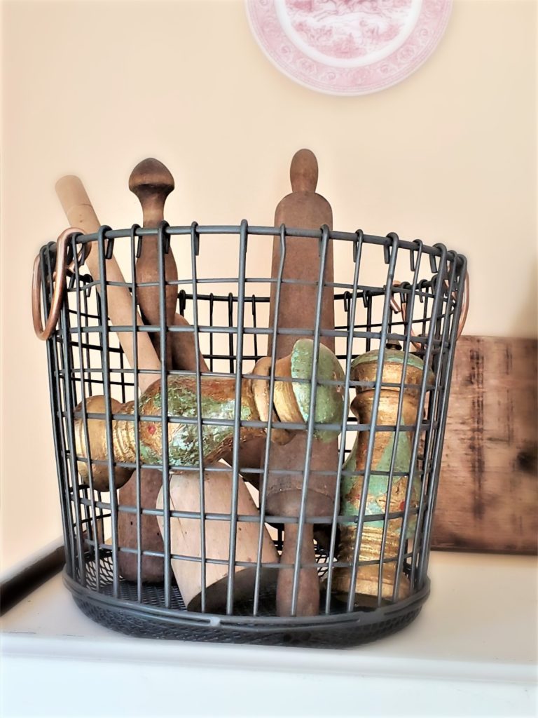 a wire basket filled with old kitchen tools and vintage  Florentine salt and pepper shakers