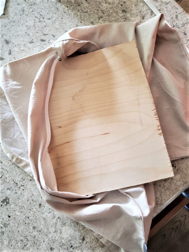 putting a piece of wood into the pillow cover for ironing on the transfer