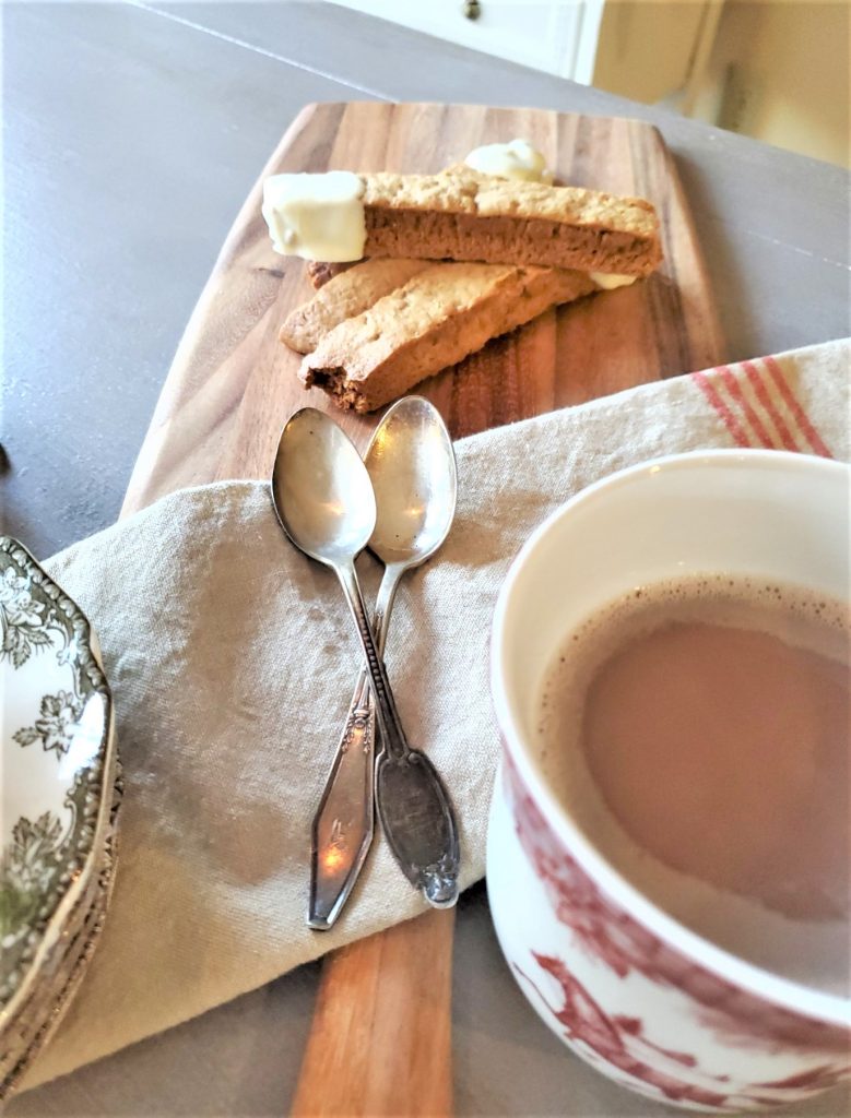 Gingerbread biscotti and a cup of coffee with silver spoons