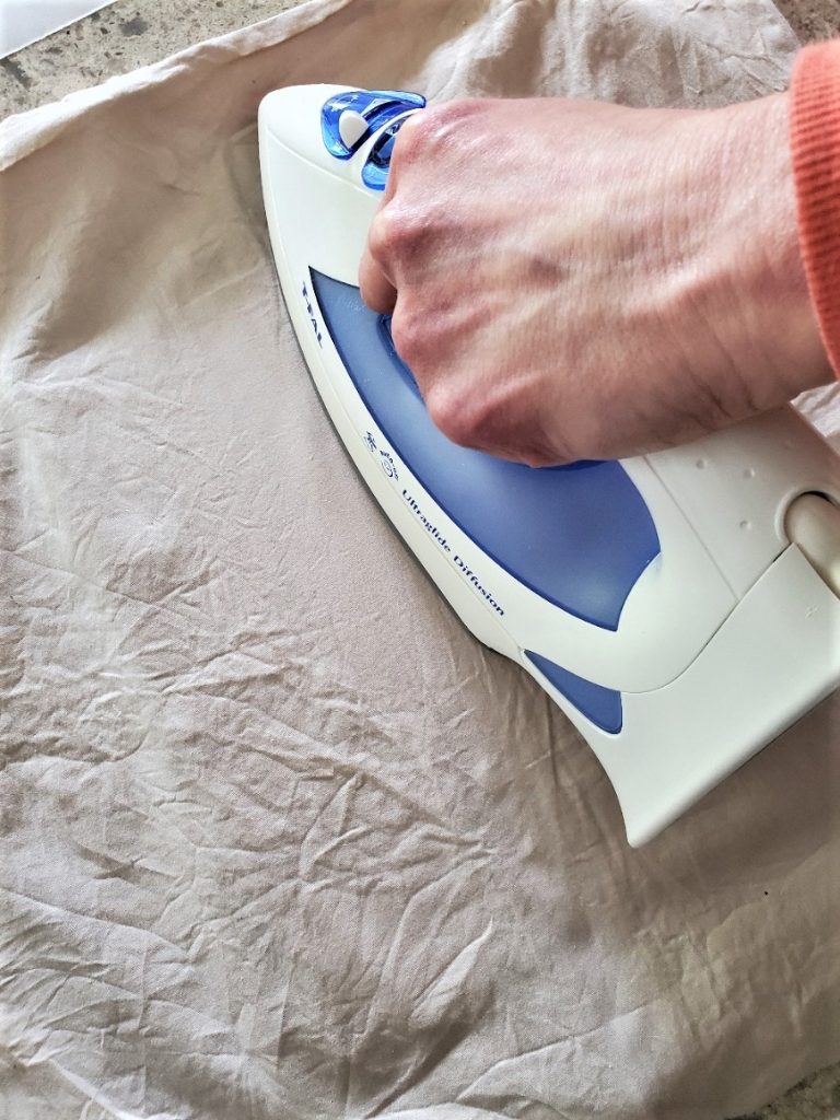 ironing the pillow cover to get the wrinkles out from squeezing the tea water out