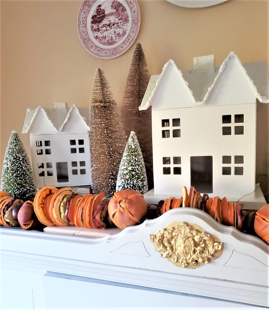 close up of snowy houses and fruit garland in a simple Christmas kitchen