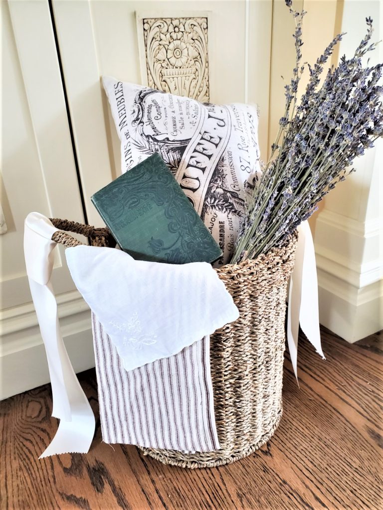 Basket decor ideas showing it filled with an antique book, dried lavender amd a pillow
