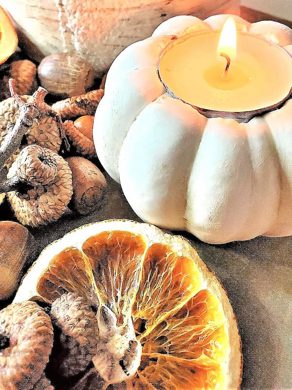 easy-pumpkin-candle-holders-in-four-steps-closeup-of-a-small-white-pumpkin-lit-with-dried-orange-slice-acorns