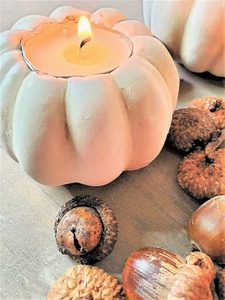 one pumpkin tealight lit with acorns