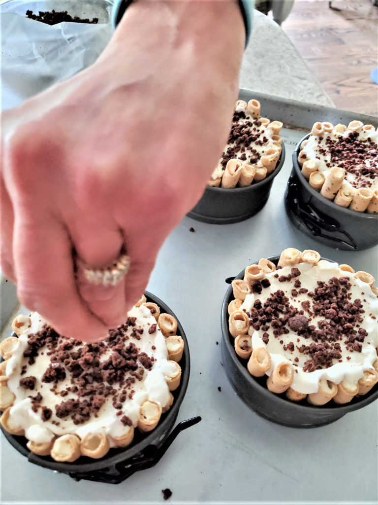 sprinkling with brownie crumble on the top of the ice cream