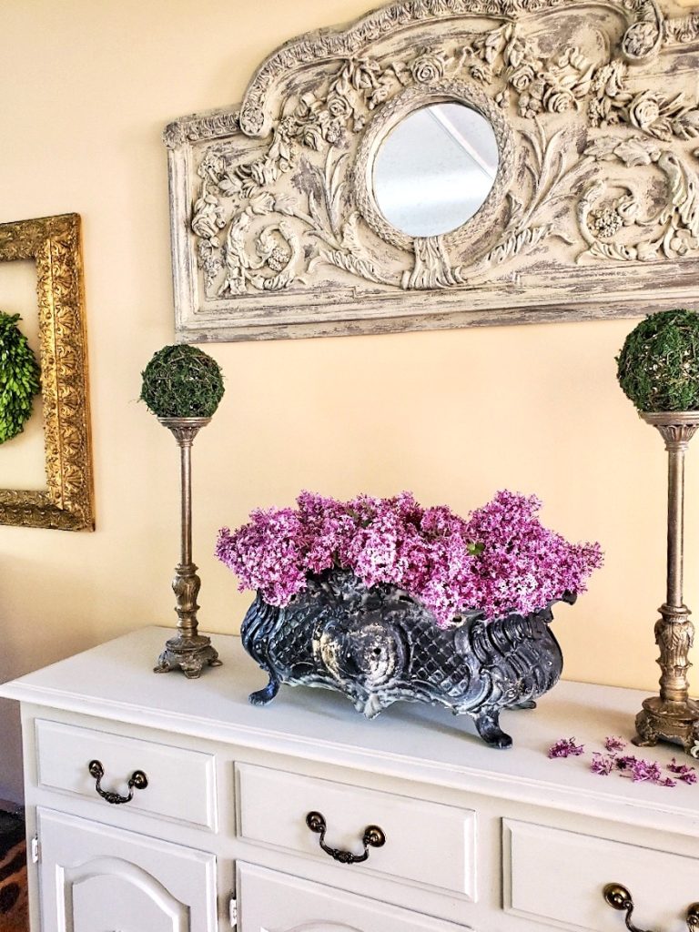 buffet-with-lilacs-in-black-jardiniere-candle-holders-with-moss-balls