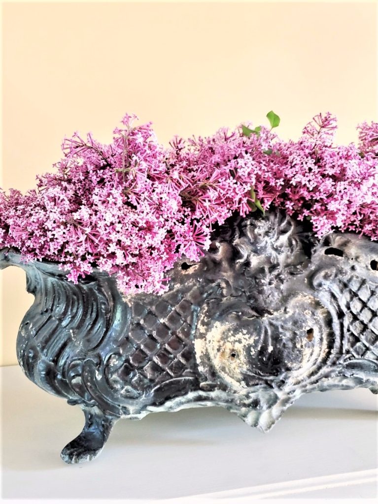 close-look-at-the-details-of-the-black-jardiniere-and-flowers