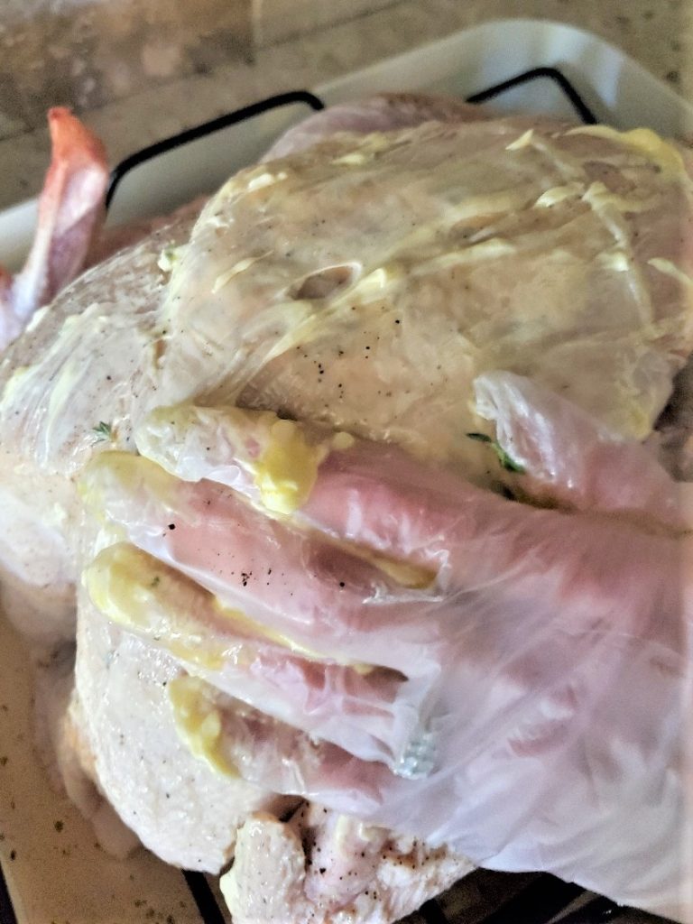 spreading-butter-oil-mixture-on-entire-turkey-for-moisture-crispy-skin
