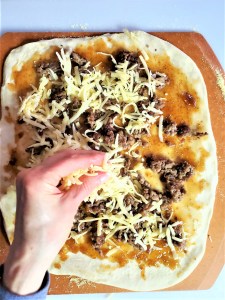 adding-cheese-fig-jam-sausage-pizza