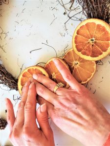 holding-orange-to-set-dried-citrus-wreath-diy