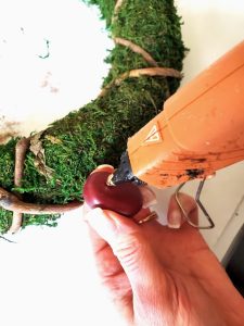 chestnut-wreath-diy-adding-hot-glue-to-chestnut