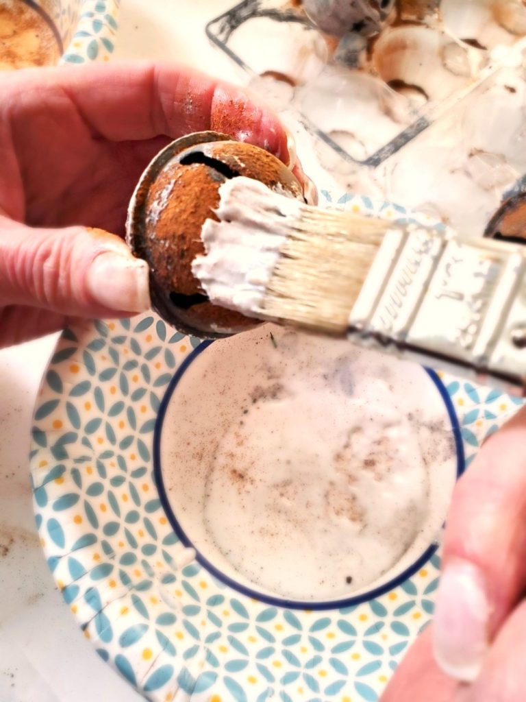 spice-up-rusty-jingle-bells-with-Mod-Podge-now-adding-glue-over-cinnamon