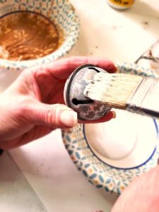 spice-up-rusty-jingle-bells-with-Mod-Podge now-adding-first-coat-of-glue