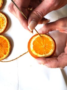 star-anise-garland-orange-slices-pulling-needle-out