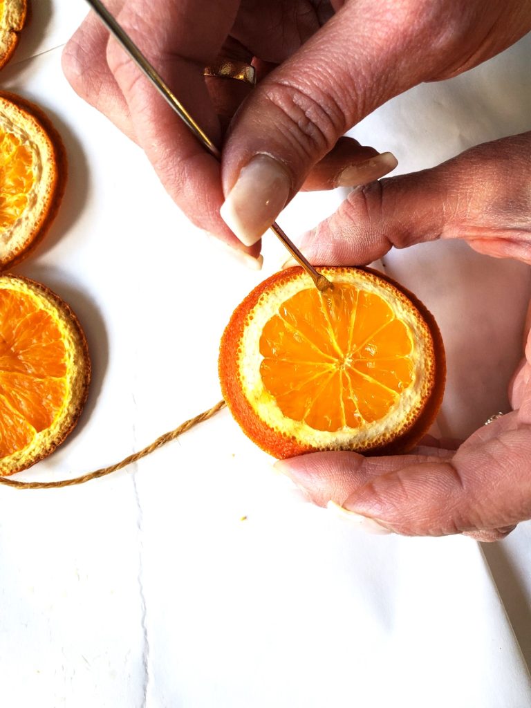 star-anise-garland-orange-slices-pulling-needle-out