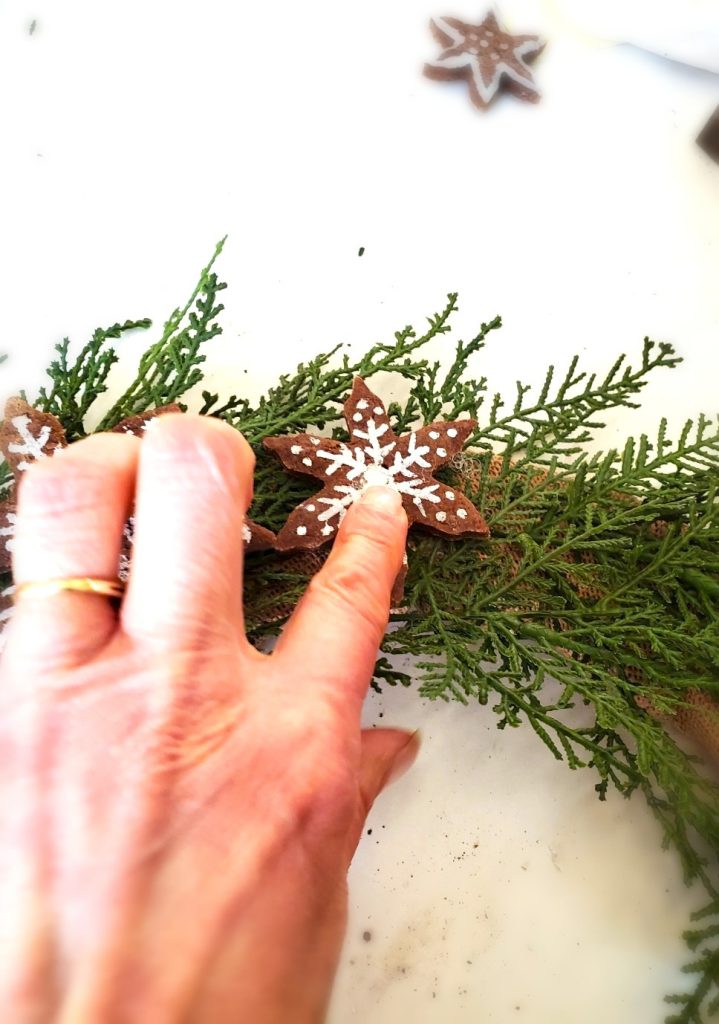 gingerbread-salt-dough-wreath-holding-snowflake-to-set