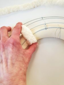 diy-chunky-yarn-wreath-holding-piece-of-yarn-to-set