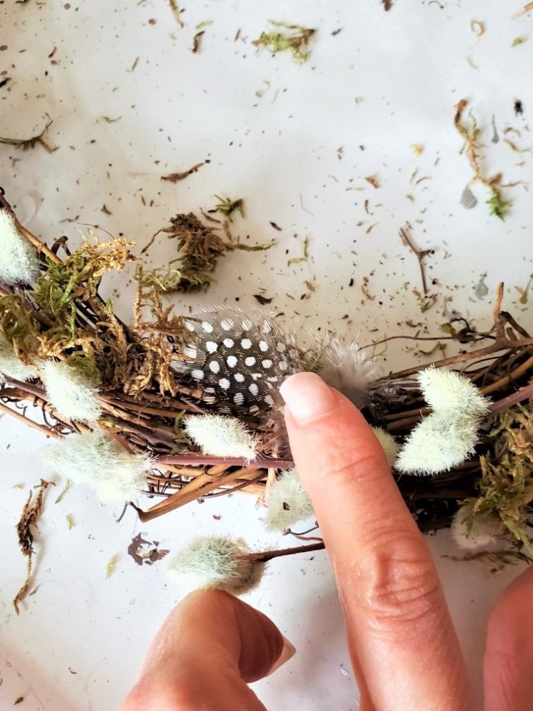 holding-dotted-feather-to-set