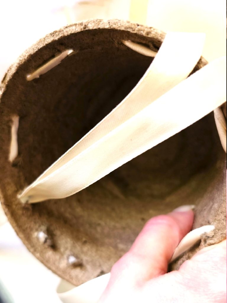 ends-of-ribbon-pushed-through-holes-on-pot-edge