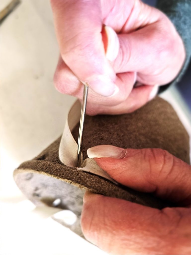pushing-ribbon-through-holes-on-pot-with-a-large-needle