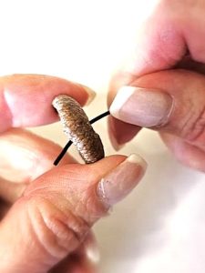 me-pushing-coated-wire-through-the-hole-on-cap