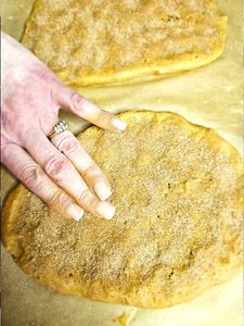 lightly-tapping-the-cinnamon-sugar-into-dough