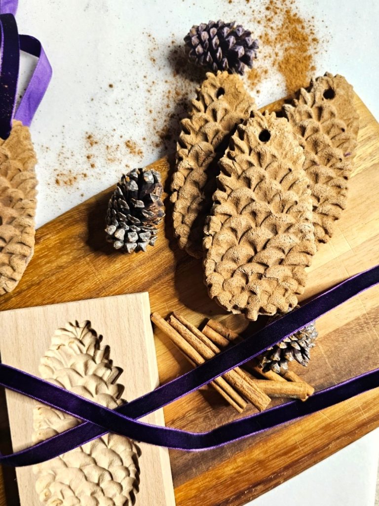 molded-cinnamon-salt-dough-ornaments-to-make-now-pinecones-molded-purple-ribbon-mold-and-cinnamon-sticks