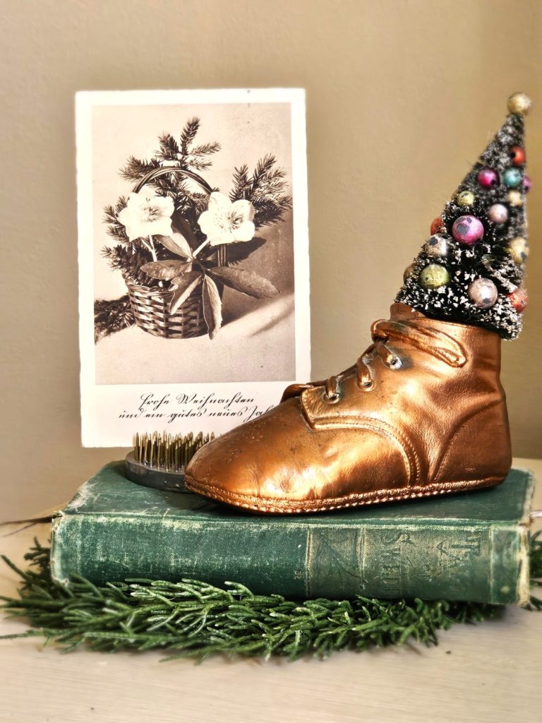 bronze-baby-shoe-on-green-book-vintage-post-card