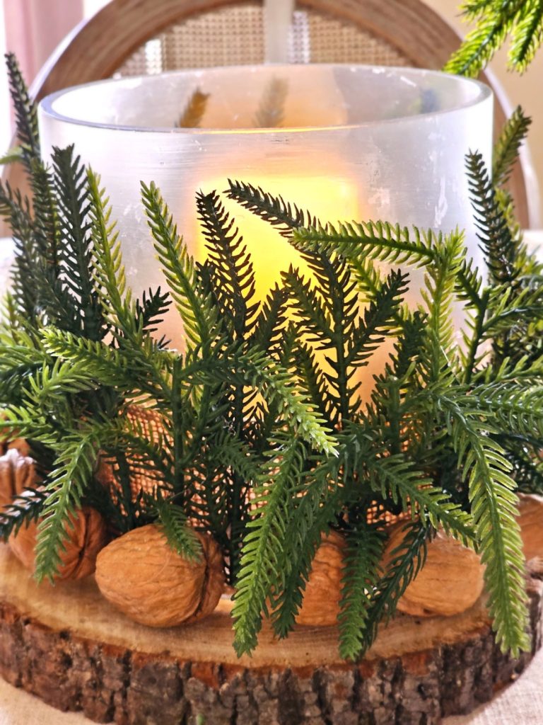 walnuts-in-the-shell-with-christmas-greens-glass-vase-battery-operated-candle-on-wood