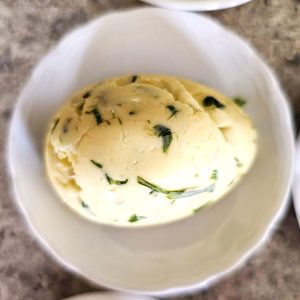 make-chive-butter-now-so-easy-close-look-at-egg-shaped-butter-on-small-round-dish-featured-image