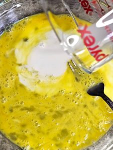cornflake-french-toast-recipe-you-need-to-try-now-pouring-milk-into-eggs
