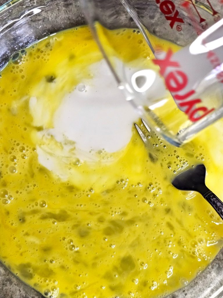 cornflake-french-toast-recipe-you-need-to-try-now-pouring-milk-into-eggs
