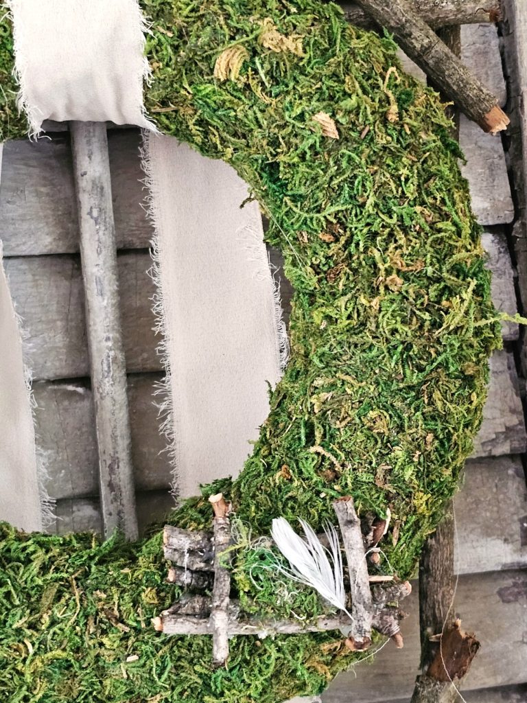 don't-miss-out-on-easy-spring-decorating-ideas-closer-look-at-moss-wreath-nest-made-from-sticks-and-a-feather