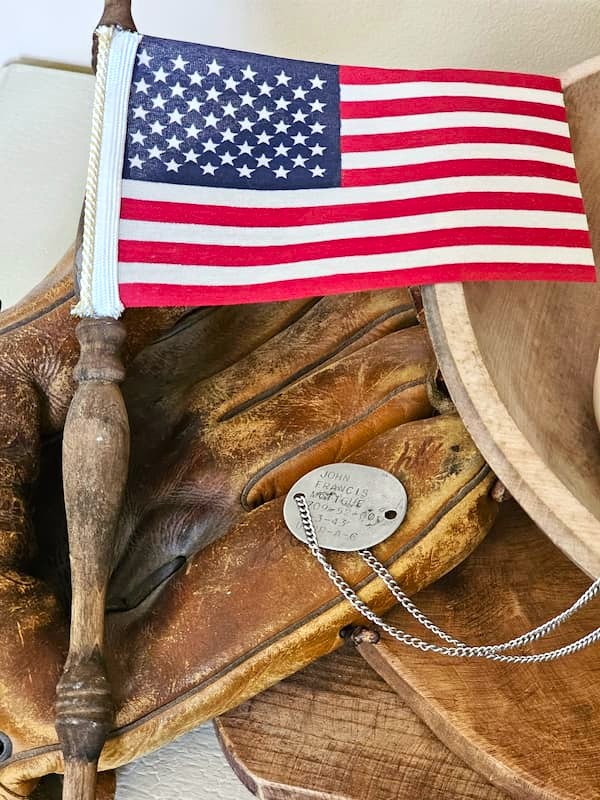 a-flag-laying-on-an-old-baseball-glove-with-dog-tags-from-world-war-two