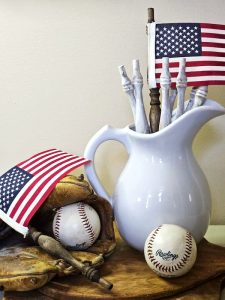 flags-in-a-white-pitcher-baseballs-and-old-painted-spindles