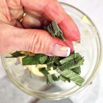 10-minute-sage-butter-sauce-recipe-me-adding-chopped-sage-for-flavored-butter-feature-image