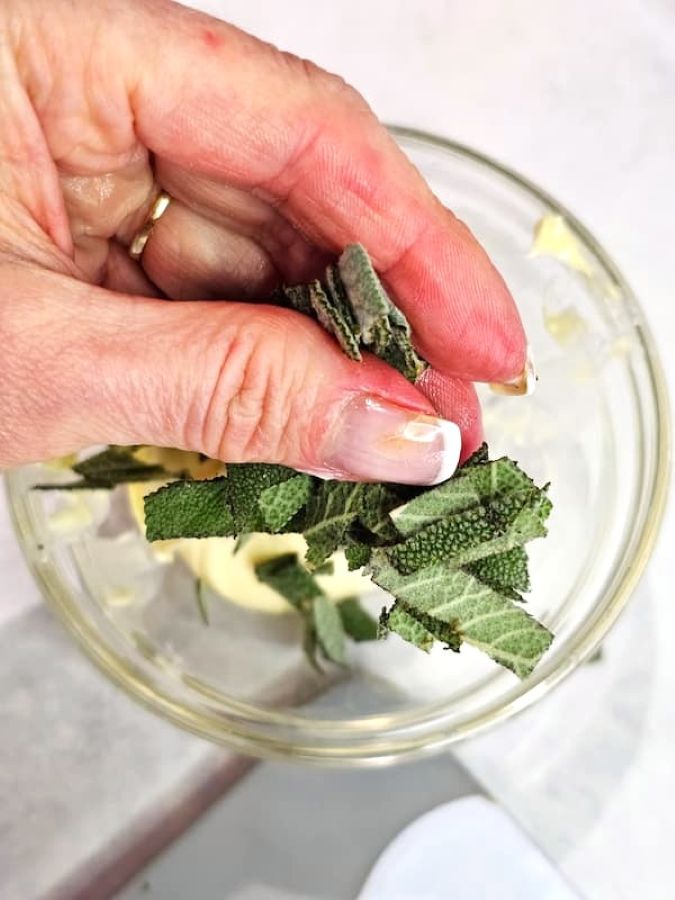 10-minute-sage-butter-sauce-recipe-me-adding-chopped-sage-for-flavored-butter-feature-image
