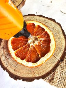 DIY-natural-wreath-with-organic-touches-me-adding-glue-to-the-center--of-orange