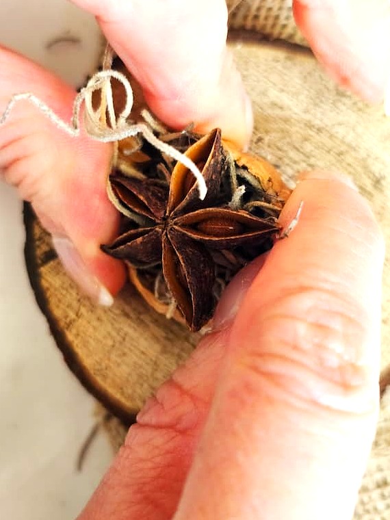 DIY-natural-wreath-with-organic-touches-me-holding-another-shell-to-set-filled-with-anise